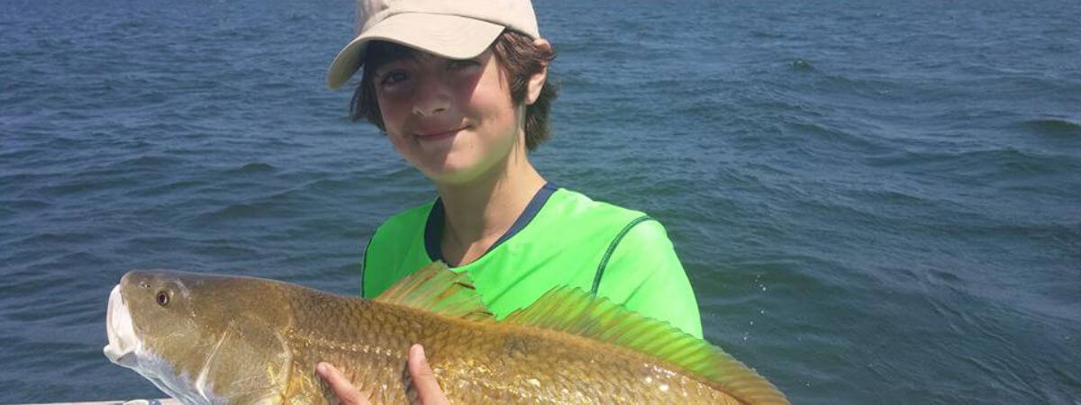 Young angler holding a big red drum caught on the Pamlico Sound