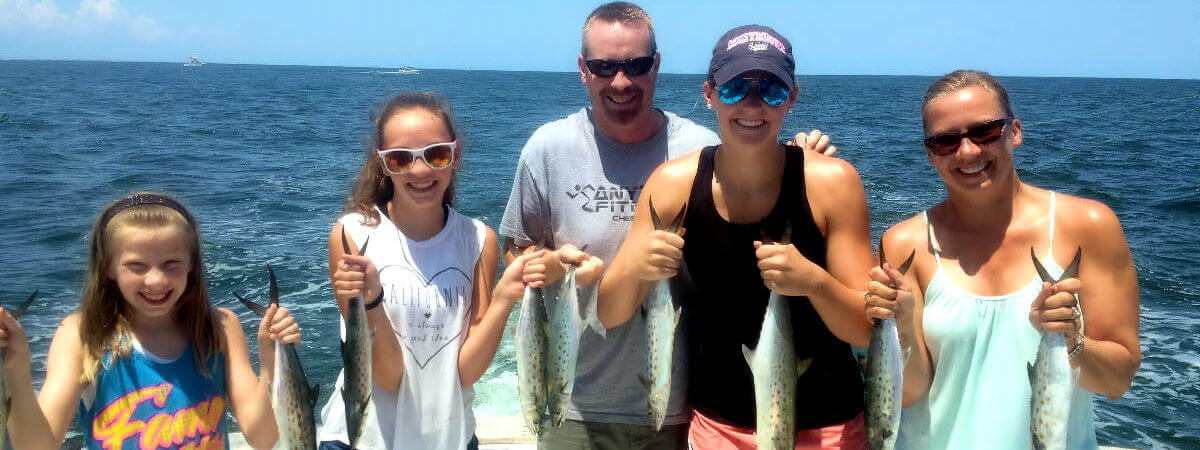 Family enjoying Outer Banks inshore charter spanish mackerel catch